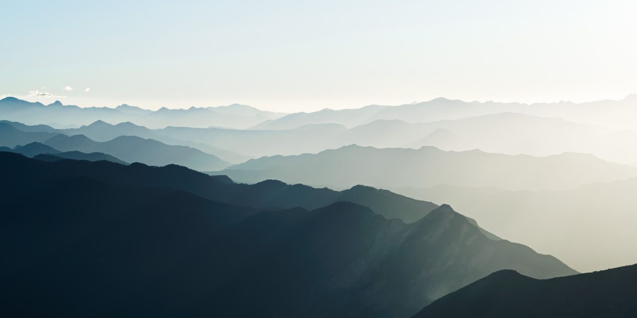 Layered mountain ridges fading into morning haze